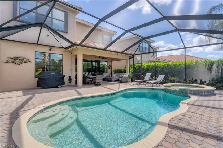 View of pool featuring a patio, area for grilling, an outdoor living space, an in ground hot tub, and glass enclosure