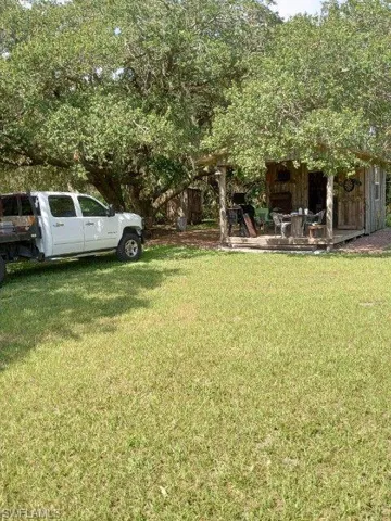 View of grassy yard with a patio area