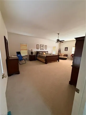 Bedroom featuring light carpet and a ceiling fan