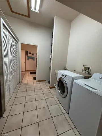 Laundry room with light tile patterned floors and washer and dryer