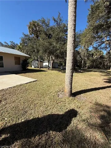 View of green lawn with a patio area