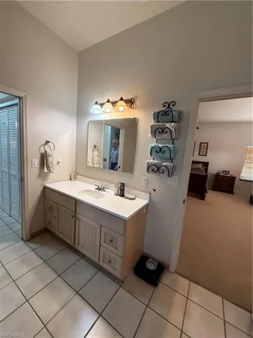 Bathroom with vanity, light carpet, and light tile patterned floors