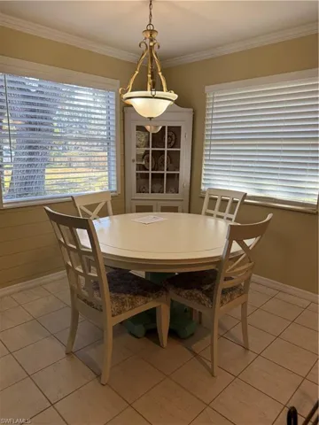 Dining space featuring crown molding and light tile patterned flooring