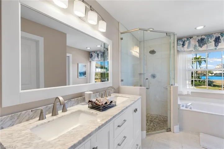 Full bath with double vanity, a bath, a stall shower, recessed lighting, and light tile patterned flooring