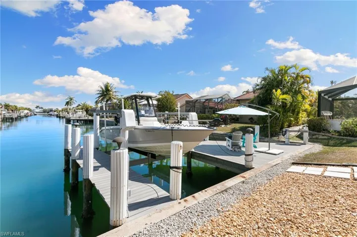 Dock area featuring boat lift and a water view