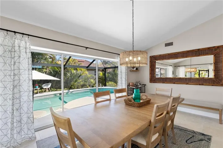 Dining area with lofted ceiling, plenty of natural light, and a sunroom
