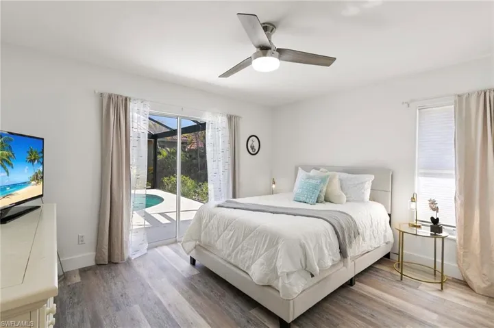 Bedroom with access to outside, wood finished floors, and ceiling fan