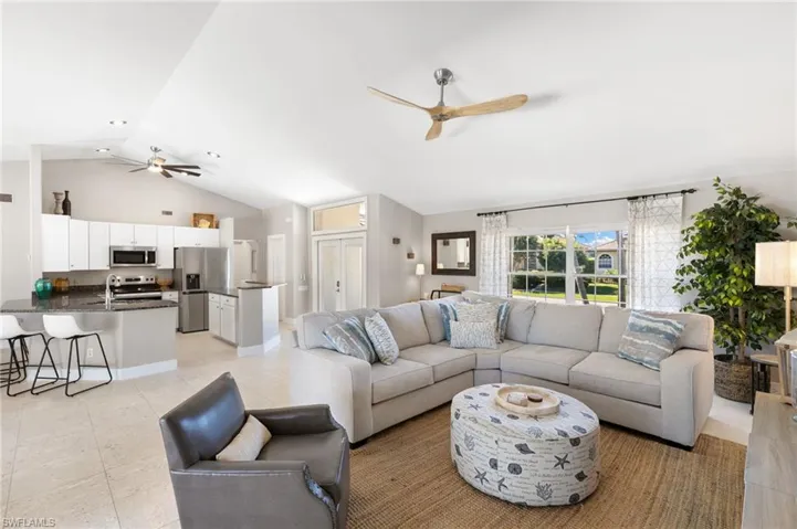 Living room featuring ceiling fan and a high ceiling