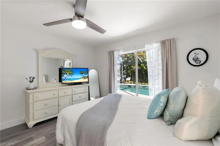 Bedroom featuring access to outside, dark wood finished floors, and ceiling fan