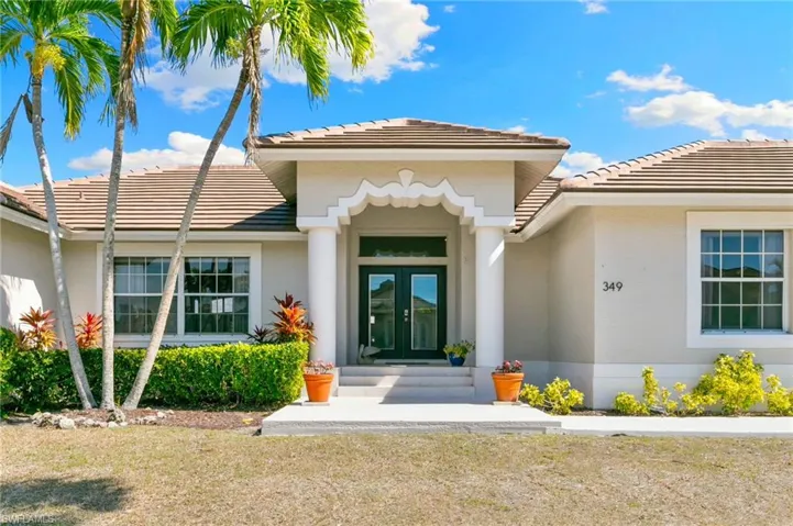 Doorway to property with french doors, a tiled roof, and stucco siding