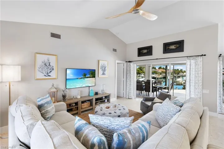 Tiled living area with lofted ceiling and ceiling fan