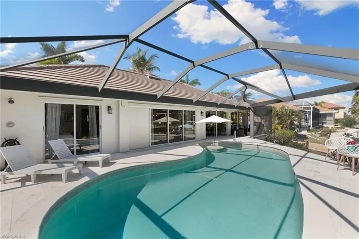Outdoor pool with a sunroom, a patio, and a lanai