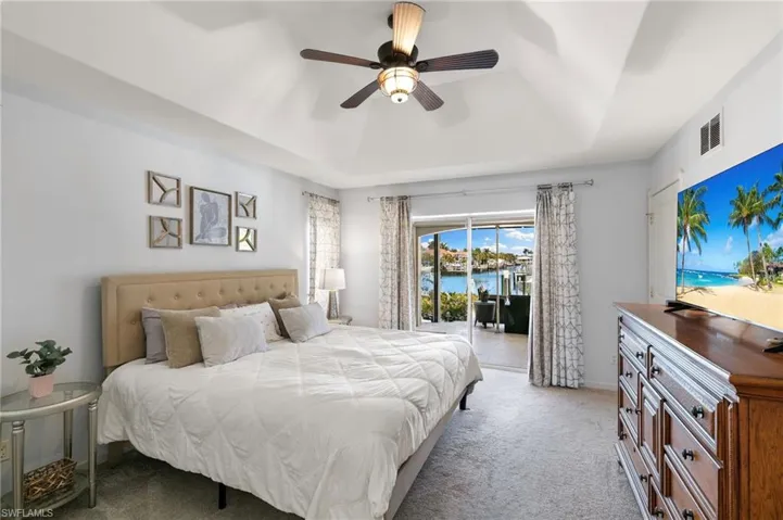 Bedroom featuring carpet, a raised ceiling, a ceiling fan, and access to outside