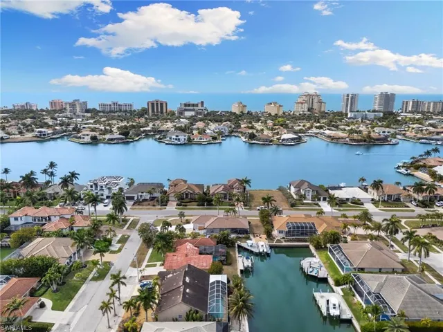 Aerial perspective of suburban area with city skyline and a large body of water