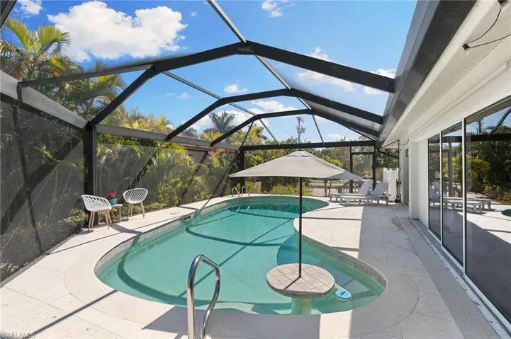 Swimming pool featuring a patio, a lanai, and a sunroom