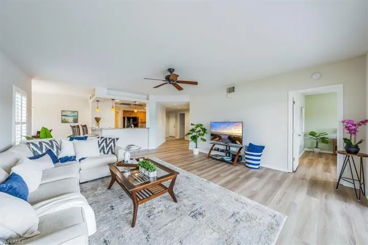 Living room with ceiling fan and light hardwood / wood-style floors