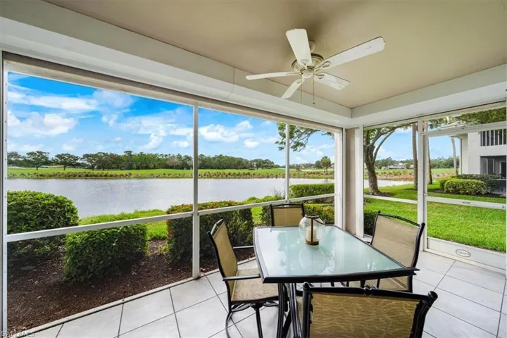 Unfurnished sunroom with ceiling fan and a water view