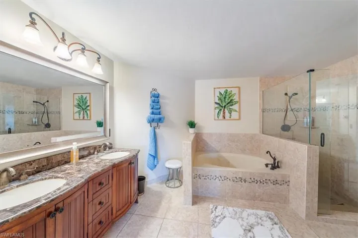 Bathroom featuring dual bowl vanity, independent shower and bath, and tile floors