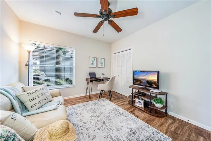 Living room featuring dark wood-type flooring and ceiling fan
