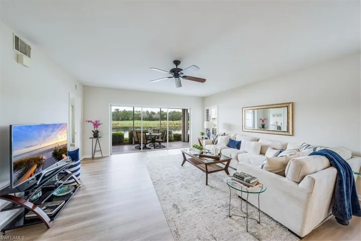 Living room with ceiling fan and light hardwood / wood-style floors