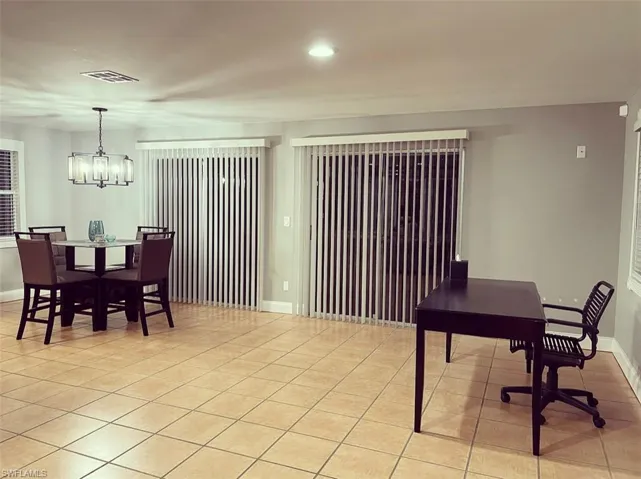Dining room with suspended lighting and light tile patterned floors
