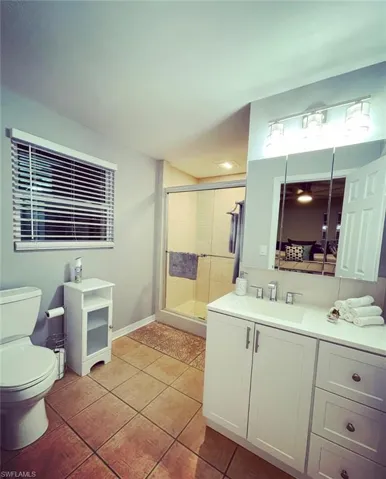 Bathroom featuring a shower stall, vanity, and light tile patterned floors