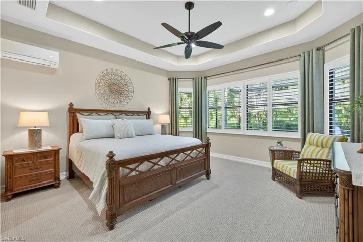 Primarty Bedroom with Carpet Overlooking Screened Lanai, Tray ceiling, Split Wall-Mounted Air Conditioner, Ceiling Fan, Plantation Shutters