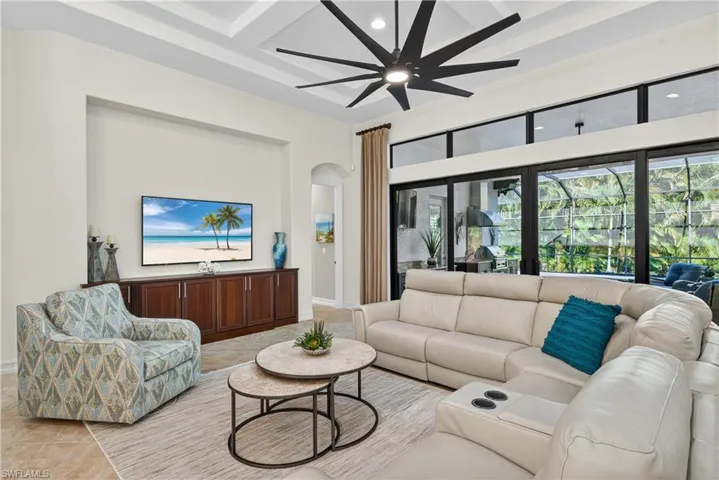 Living Room Featuring Coffered Ceilings, Recessed Lighting, Upgraded Ceiling Fan with Built-In Remote, and Full Impact Glass Sliders to Screened Lanai