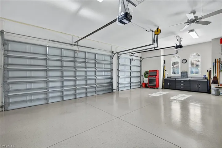 3 Car Garage Featuring Epoxy Coated Floor, Ceiling fan, Workshop/Bench, Plantation Shutters, and Garage Door Opener