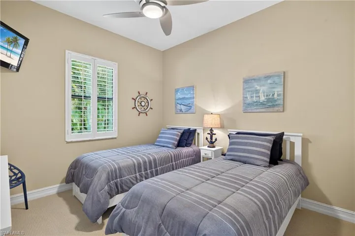 Carpeted 2nd Guest Bedroom Featuring High Baseboards, Ceiling Fan, and Plantation Shutters.
