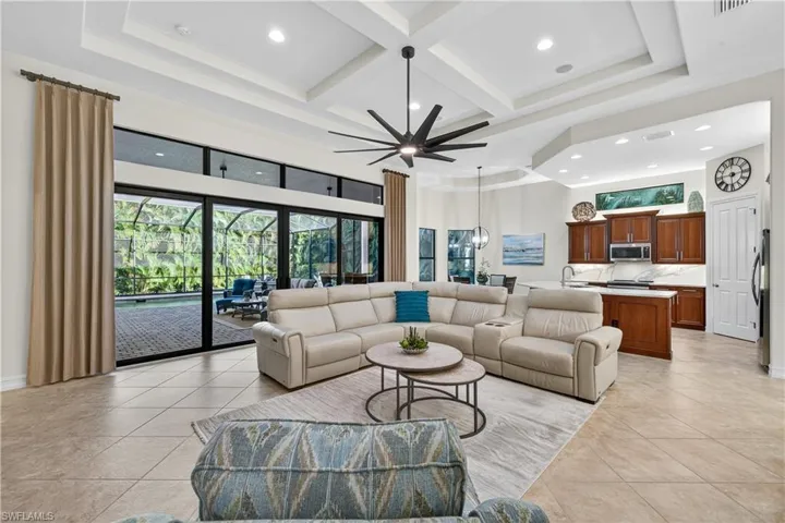 Living Room with Coffered Ceiling, Recessed lighting,, and Upgraded Ceiling Fan with Remote Control, and Full Impact Glass Sliders to Screened Lanai