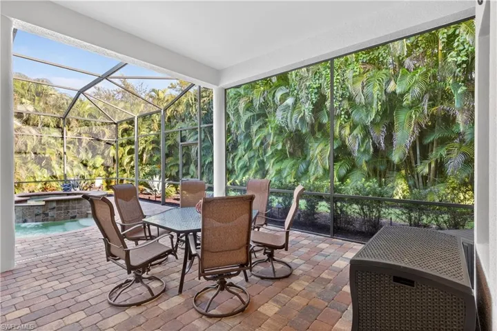 View of Screened Lanai Featuring Outdoor Dining Area, Saltwater Pool and Spa, Oversized Outdoor Covered Lanai On Upgraded Landscaped Private Lot