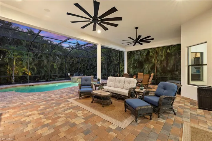 Oversized Lanai Featuring Upgraded Ceiling Fans, Saltwater Pool and Spa, Outdoor Area for Loungin and Entertaining, and Beautiful Nightscape Lighting