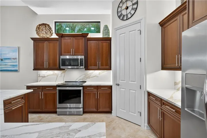 Kitchen Featuring Gorgeous Quartz Counters and Backsplash, Convection Oven/Microwave and Induction Cooktop, Walk-In Pantry, and Newer Stainless Steel Appliances