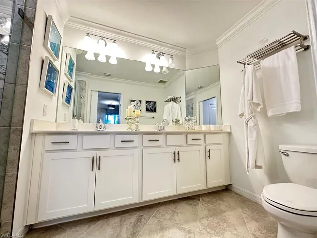 Bathroom featuring toilet, tile patterned flooring, and crown molding