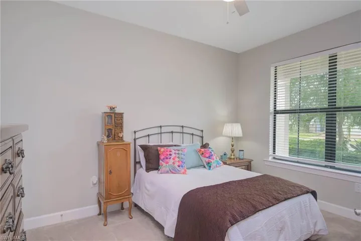 Carpeted bedroom featuring ceiling fan