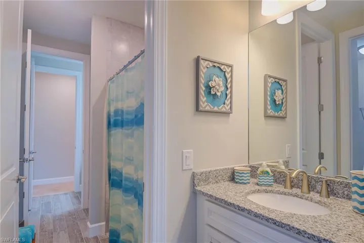 Bathroom featuring a shower with curtain and vanity