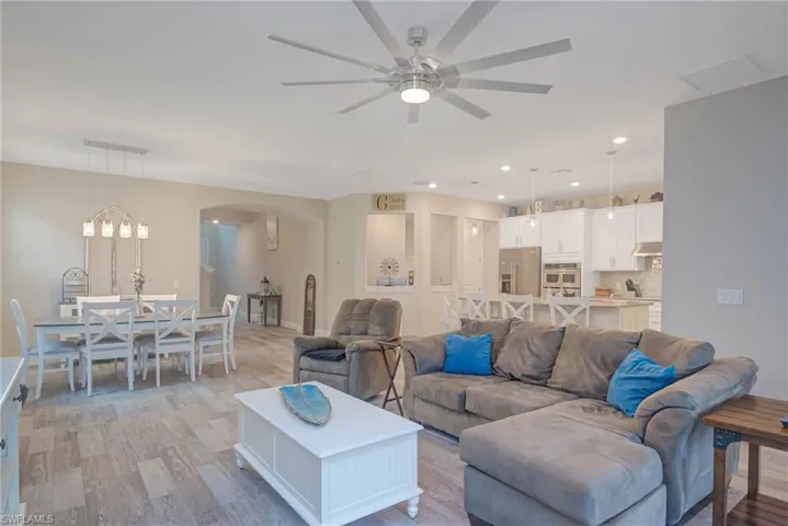 Living room with light hardwood / wood-style floors and ceiling fan