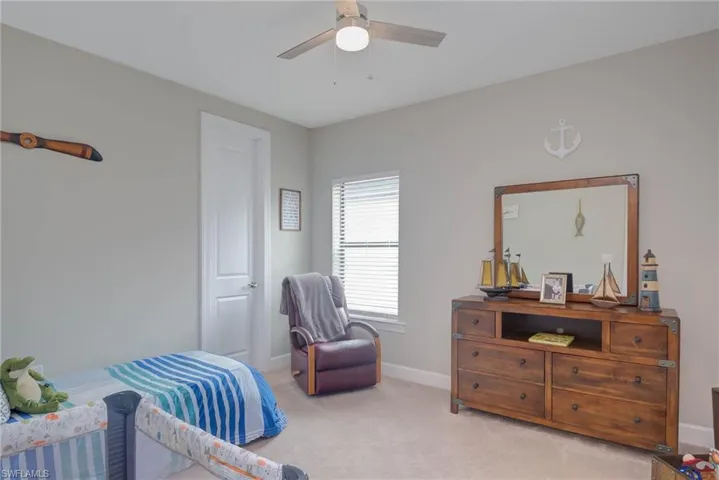 Bedroom with light colored carpet and ceiling fan