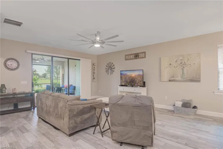 Living room featuring light hardwood / wood-style flooring, a wealth of natural light, and ceiling fan