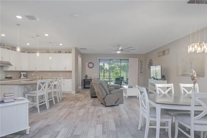 Living room with ceiling fan, sink, and light hardwood / wood-style floors