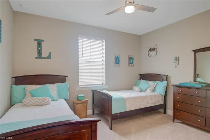 Carpeted bedroom featuring ceiling fan