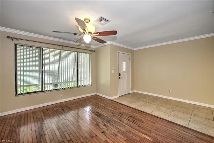 Unfurnished room with hardwood / wood-style flooring, ornamental molding, and ceiling fan