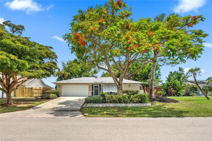 Ranch-style home featuring a garage and a front lawn