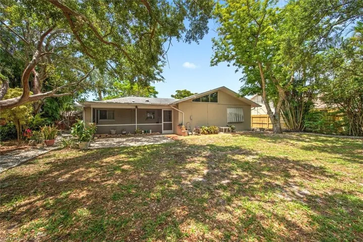 Rear view of property with a yard and central air condition unit