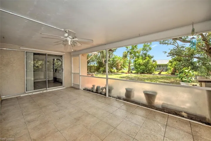 Unfurnished sunroom featuring ceiling fan