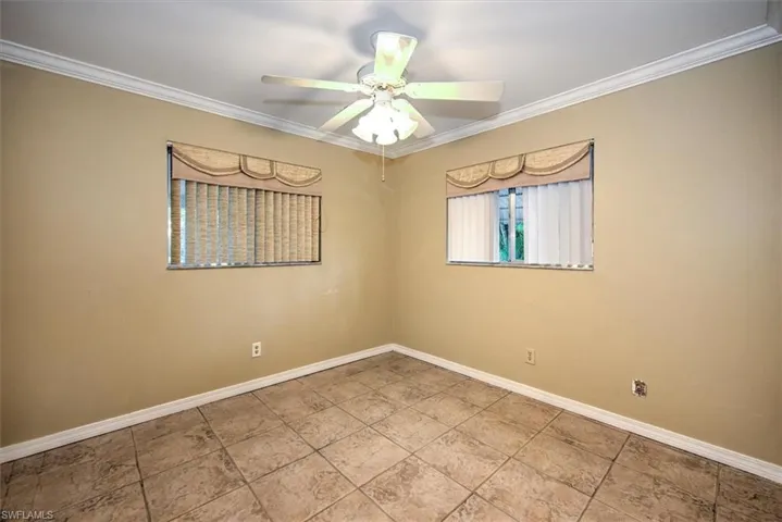 Unfurnished room featuring crown molding, tile flooring, and ceiling fan