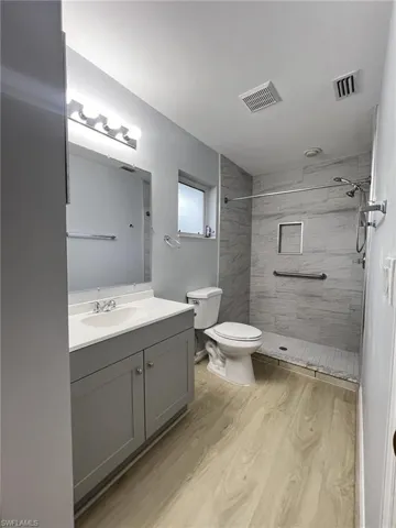Bathroom featuring vanity, a stall shower, and light wood-style flooring