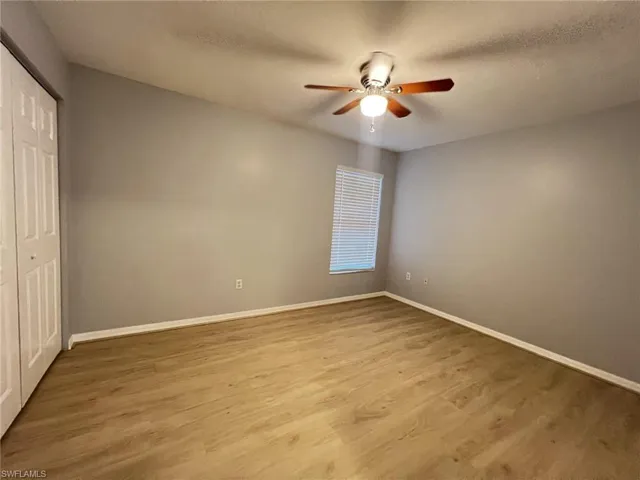Unfurnished bedroom with a closet, light wood-style floors, ceiling fan, and a textured ceiling