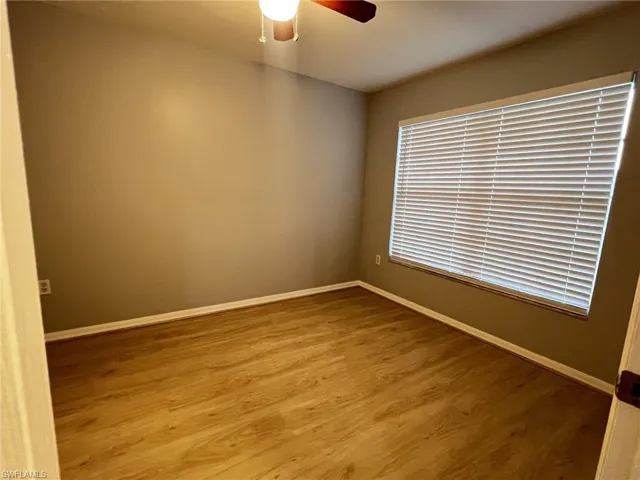 Empty room featuring light wood-type flooring and a ceiling fan